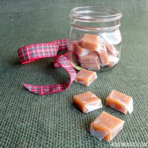 clear glass jar filled with caramels, wrapped caramels and ribbon on the side