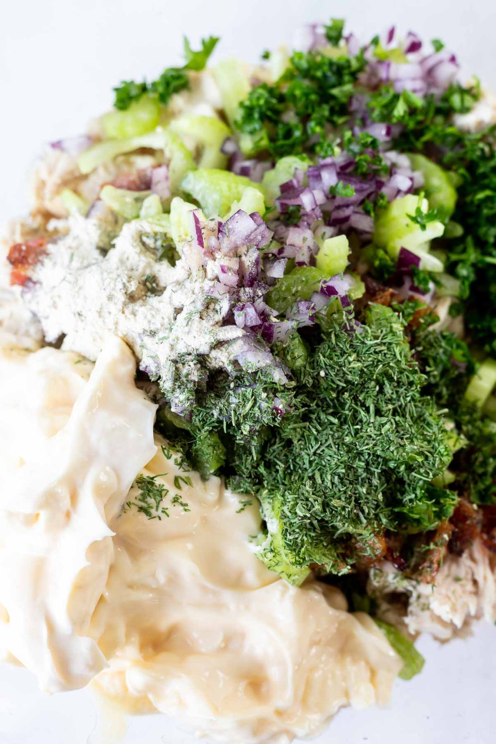 chicken salad ingredients in clear mixing bowl