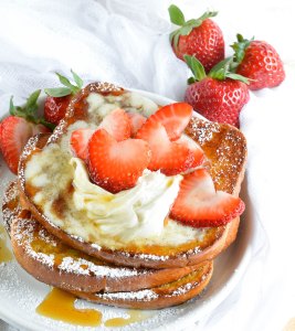 This Easy Baked French Toast Recipe is perfect for serving a crowd! Serve up this French Toast with Vanilla Mascarpone, Maple Syrup and Fresh Strawberries for the ultimate special occasion breakfast or brunch.