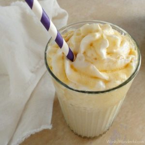 close up of creamy smoothie with purple and white striped straw