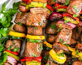 cooked steak and veggies on metal skewers