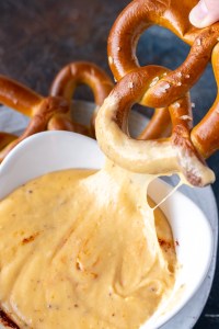 soft pretzel dipped in cheesy sauce