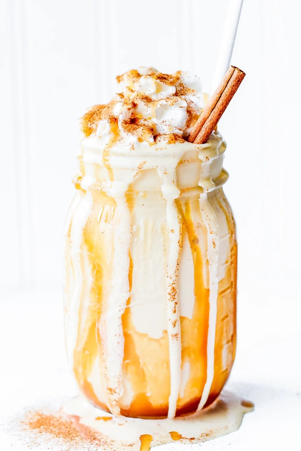 white and golden brown dripping milkshake in clear glass