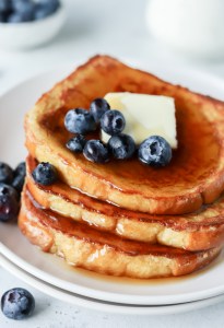 three slices with French toast topped with blueberries and syrup