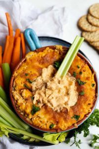 buffalo chicken dip with crackers, celery and carrots on the side