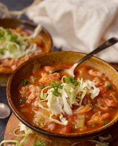 cabbage roll soup in brown bowl with spoon