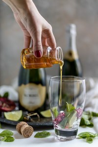 hand pouring honey into glass