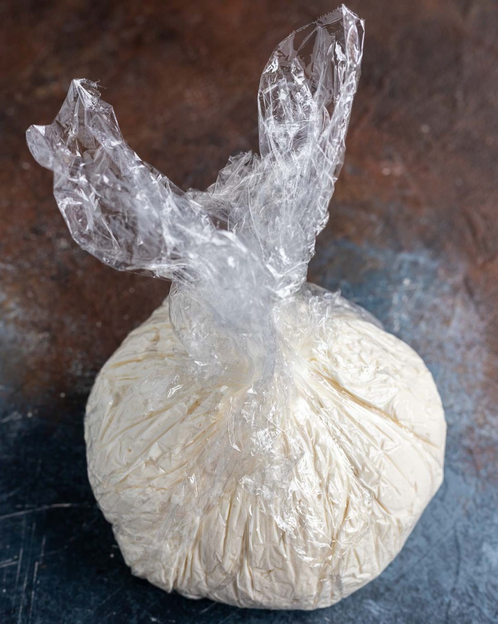 cream cheese ball wrapped in plastic wrap