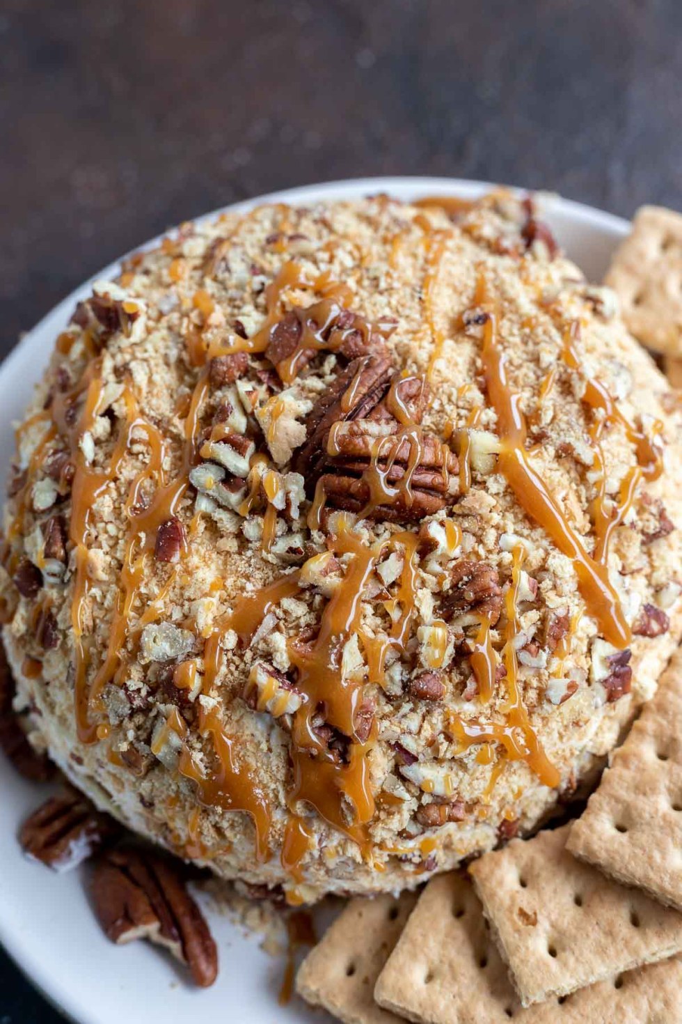 cheese ball coated in graham crackers, pecans and caramel