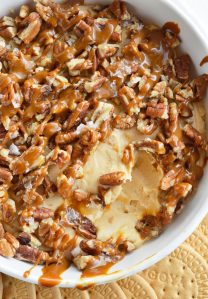 If you need a last minute dessert recipe that is sure to be a hit this Caramel Pecan Cheesecake Dip is it! Caramel marshmallow fluff cream cheese filling is topped with pecans, caramel and flaked salt. This dessert dip is so tasty and only takes 5 minutes to make!