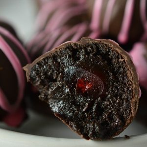 dark brown truffle ball cut in half to show cherry inside