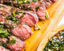 sliced steak topped with chunky green sauce