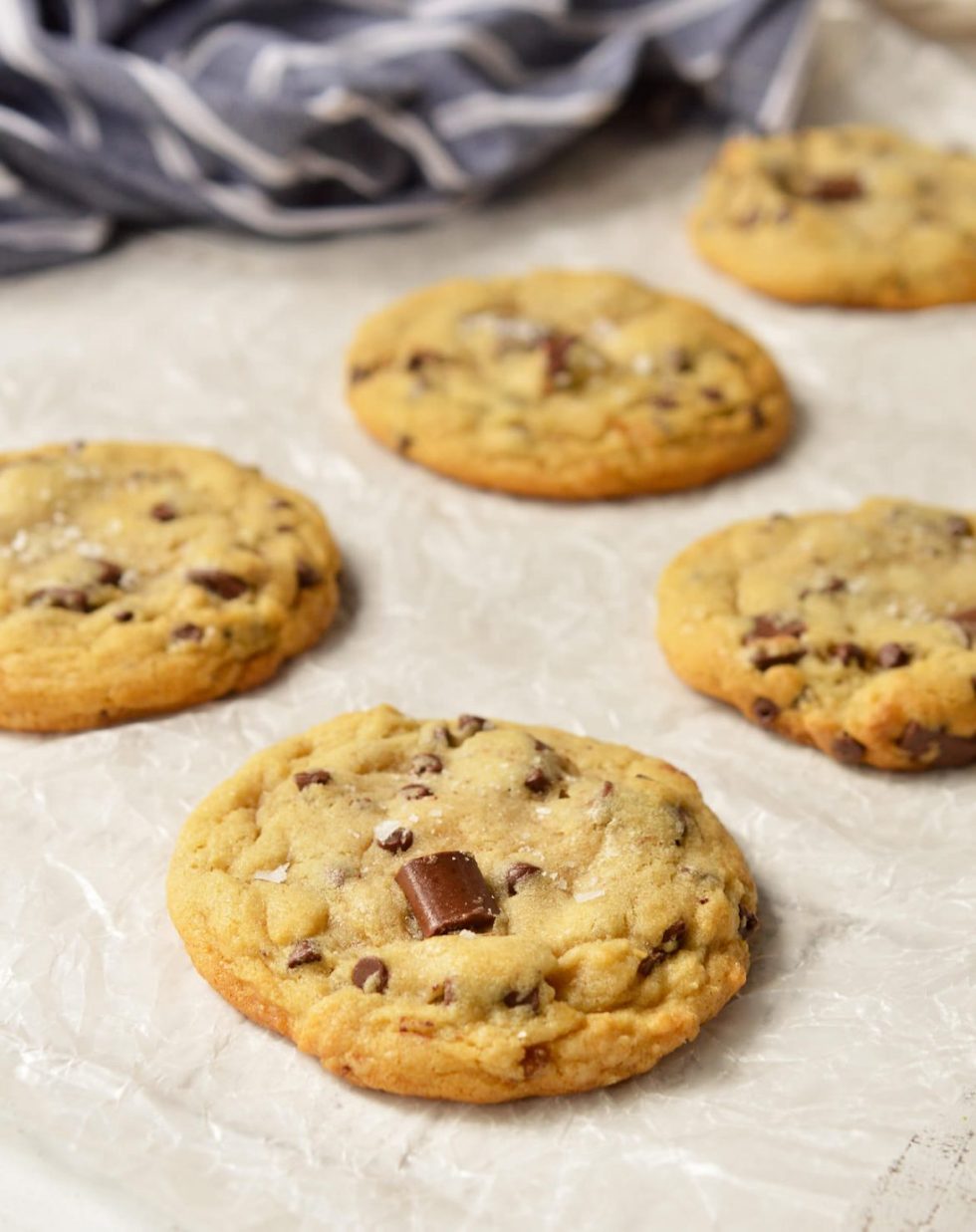 These Soft Chocolate Chip Cookies are my family's favorite treat! A special secret ingredient gives them a unique flavor and they are loaded with two types of chocolate chips! Also, this is a High Altitude Chocolate Chip Cookies Recipe. Soft, chewy, super-chocolaty and finished with a sprinkle of sea salt. #chocolatechipcookies #chocolatechipcookierecipes 