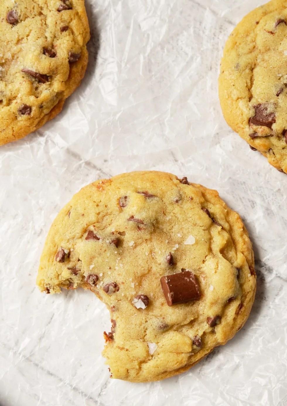 These Soft Chocolate Chip Cookies are my family's favorite treat! A special secret ingredient gives them a unique flavor and they are loaded with two types of chocolate chips! Also, this is a High Altitude Chocolate Chip Cookies Recipe. Soft, chewy, super-chocolaty and finished with a sprinkle of sea salt. #chocolatechipcookies #chocolatechipcookierecipes 