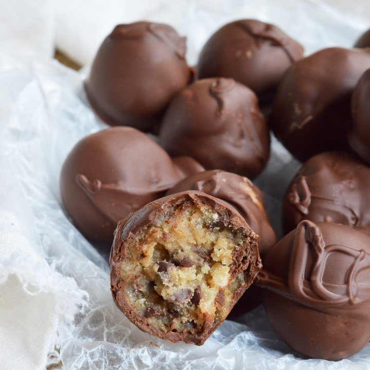 STOP what you're doing and make these Edible Cookie Dough Truffles! Chocolate chip cookie dough that is safe to eat is rolled into balls and coated with chocolate! This no-bake dessert recipe is as good as it gets!