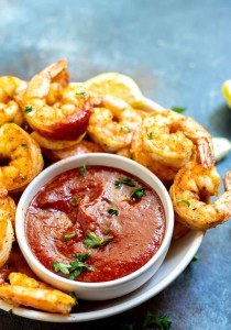 cocktail sauce in white bowl surrounded by shrimp