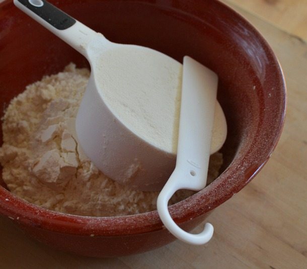 red bowl filled with flour and measuring cup