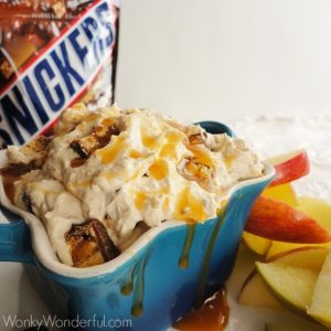 creamy candy dip in blue dish with snickers package in the background