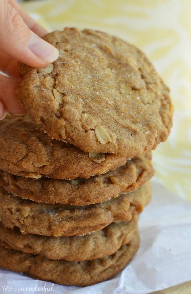 hand grabbing light brown cookie from top of stack