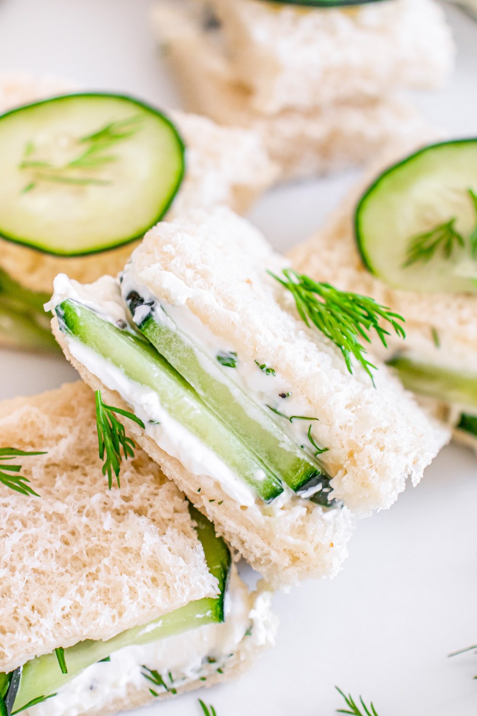 white bread with slices of cucumber and cream cheese