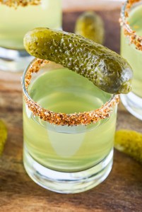 light green shot in glass topped with mini pickle