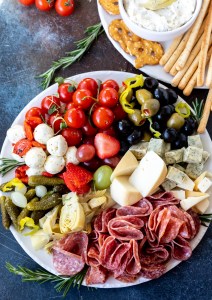 charcuterie tray next to bread sticks and pretzels