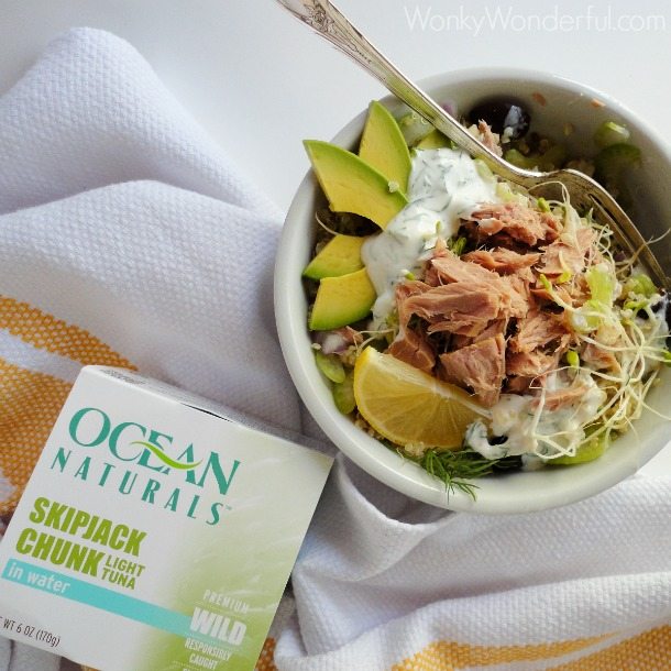 tuna quinoa bowl with fork next to canned tuna