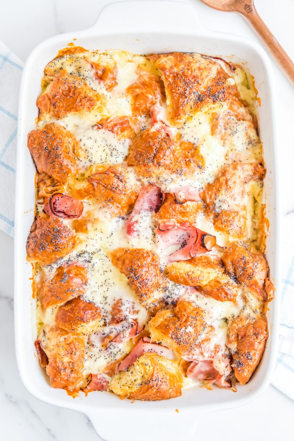 melty ham cheese and croissants in white baking dish