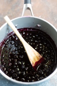 blueberry sauce in pot with wooden spoon