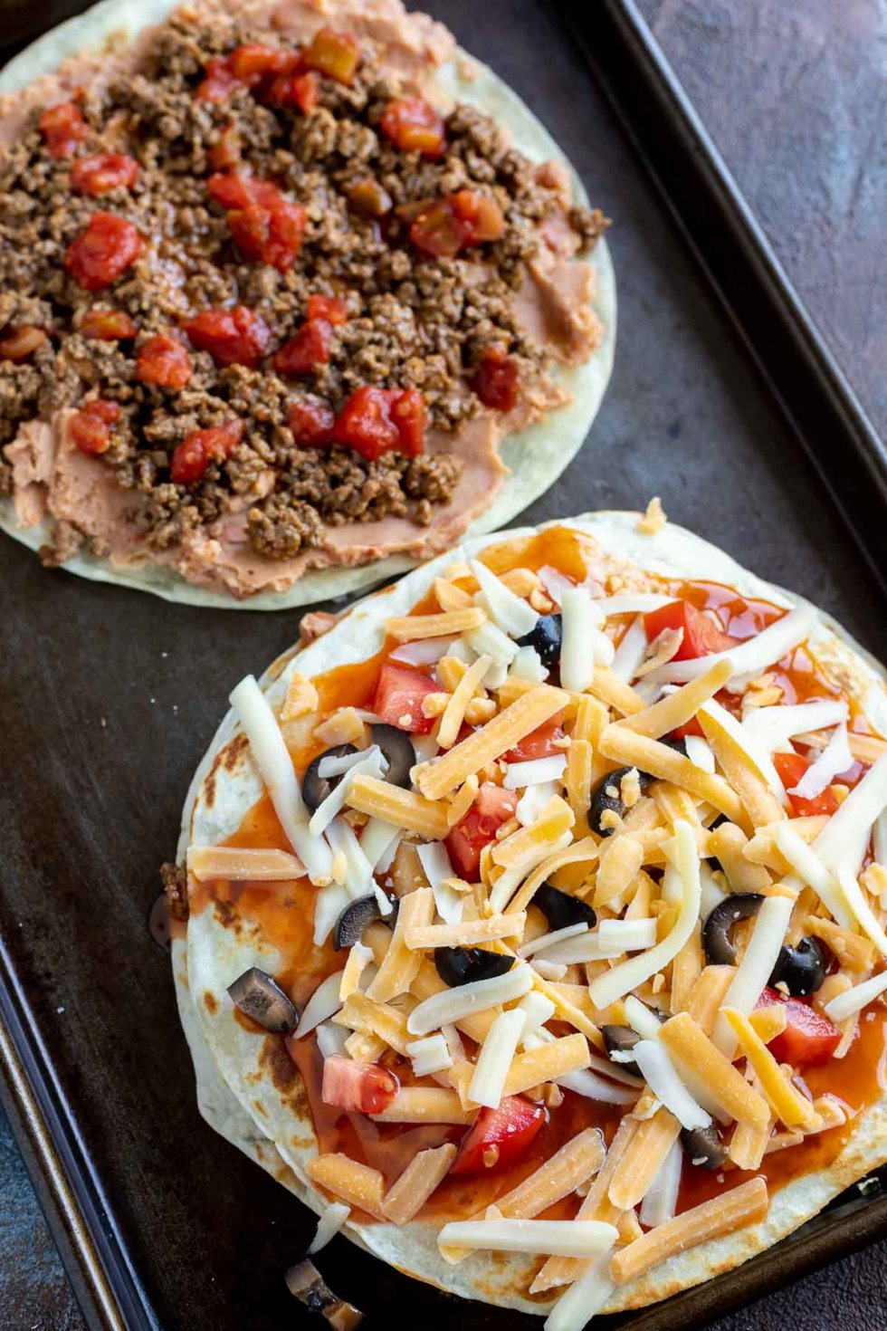 Mexican pizzas partially assembled on baking sheet