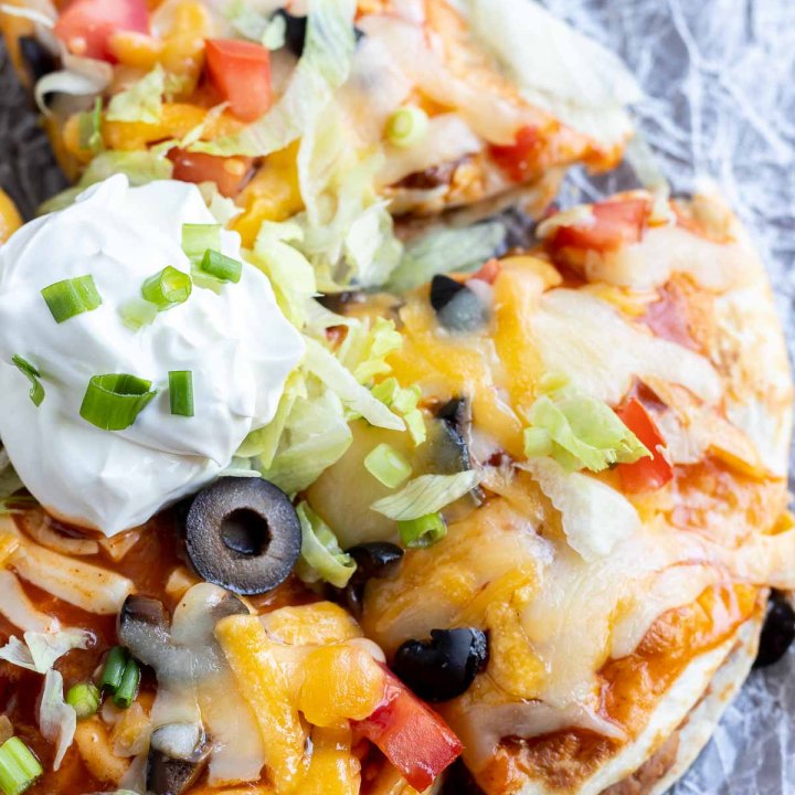 prepared Mexican pizza topped with sour cream and sliced green onions