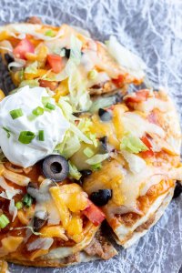 prepared Mexican pizza topped with sour cream and sliced green onions