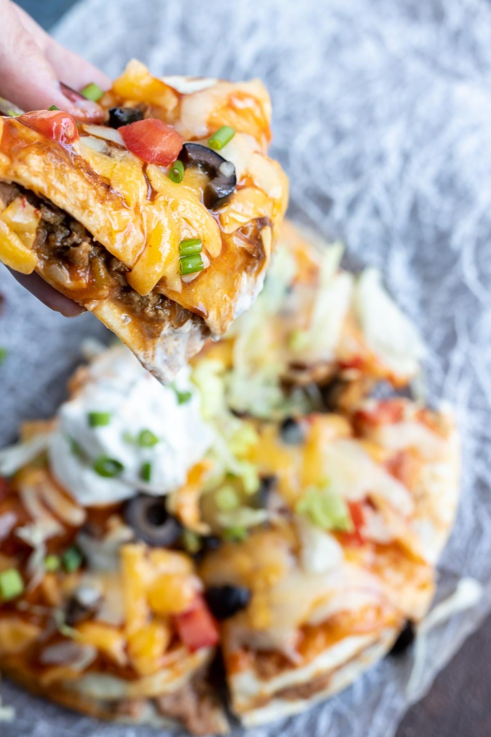 hand holding slice of Mexican pizza