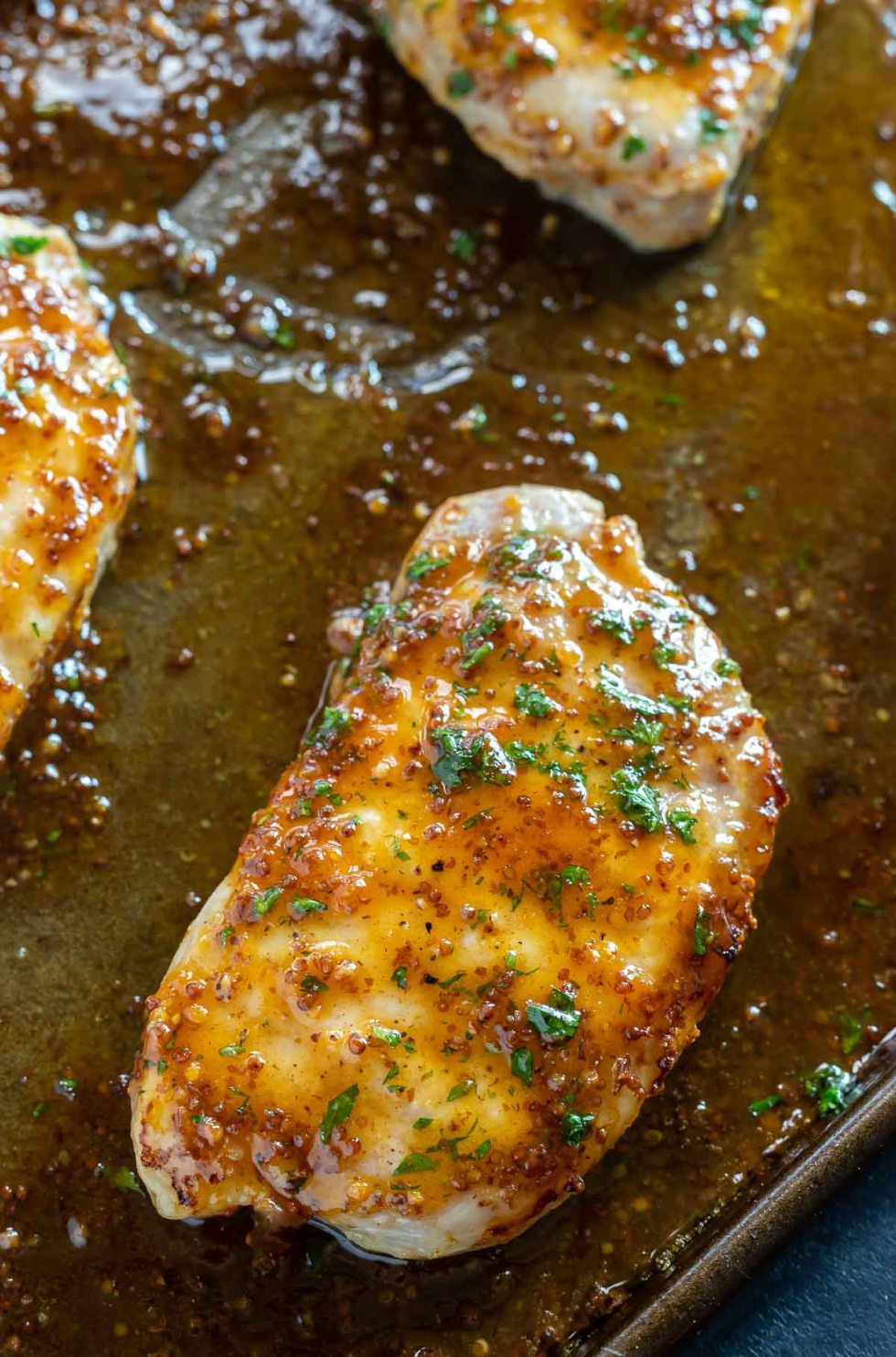 baked pork chop covered with sauce on rimmed baking sheet