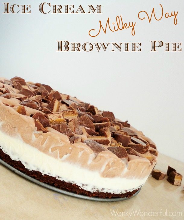 ice cream pie from the side showing layers of brownie, white ice cream, brown ice cream and chopped candy bars, photo text: ice cream Milky Way brownie pie