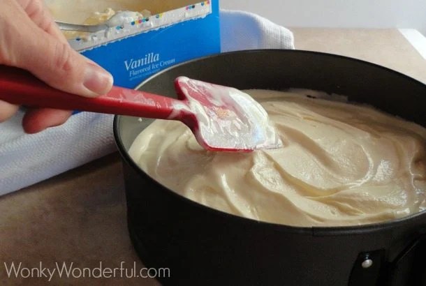 hand spreading white ice cream with spatula