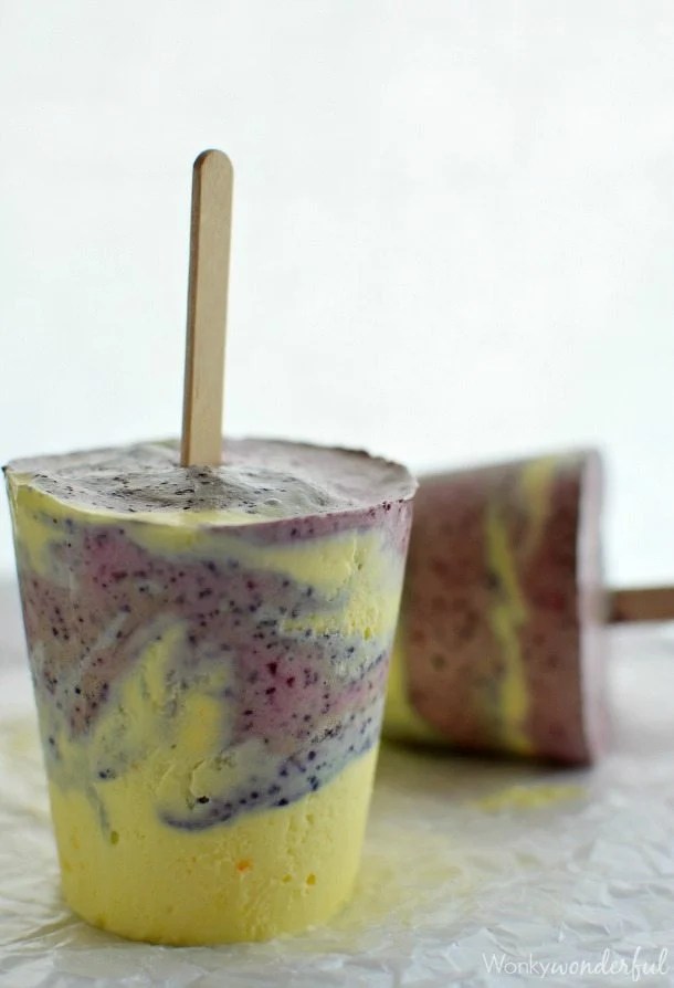 yellow and blueish purple swirl popsicle with wooden stick