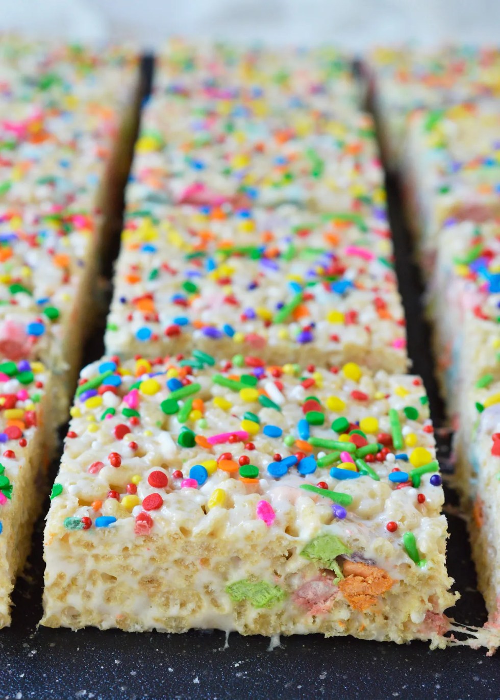 These Magical Rainbow Rice Crispy Treats are perfect for a surprise treat or a colorful unicorn party! This easy dessert recipe makes super chewy krispy treats full of magical charm marshmallows. Top them with rainbow sprinkles for the ultimate kid approved treat!