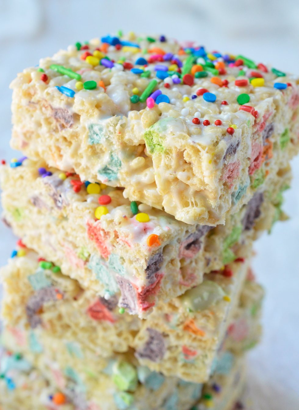 These Magical Rainbow Rice Crispy Treats are perfect for a surprise treat or a colorful unicorn party! This easy dessert recipe makes super chewy krispy treats full of magical charm marshmallows. Top them with rainbow sprinkles for the ultimate kid approved treat!