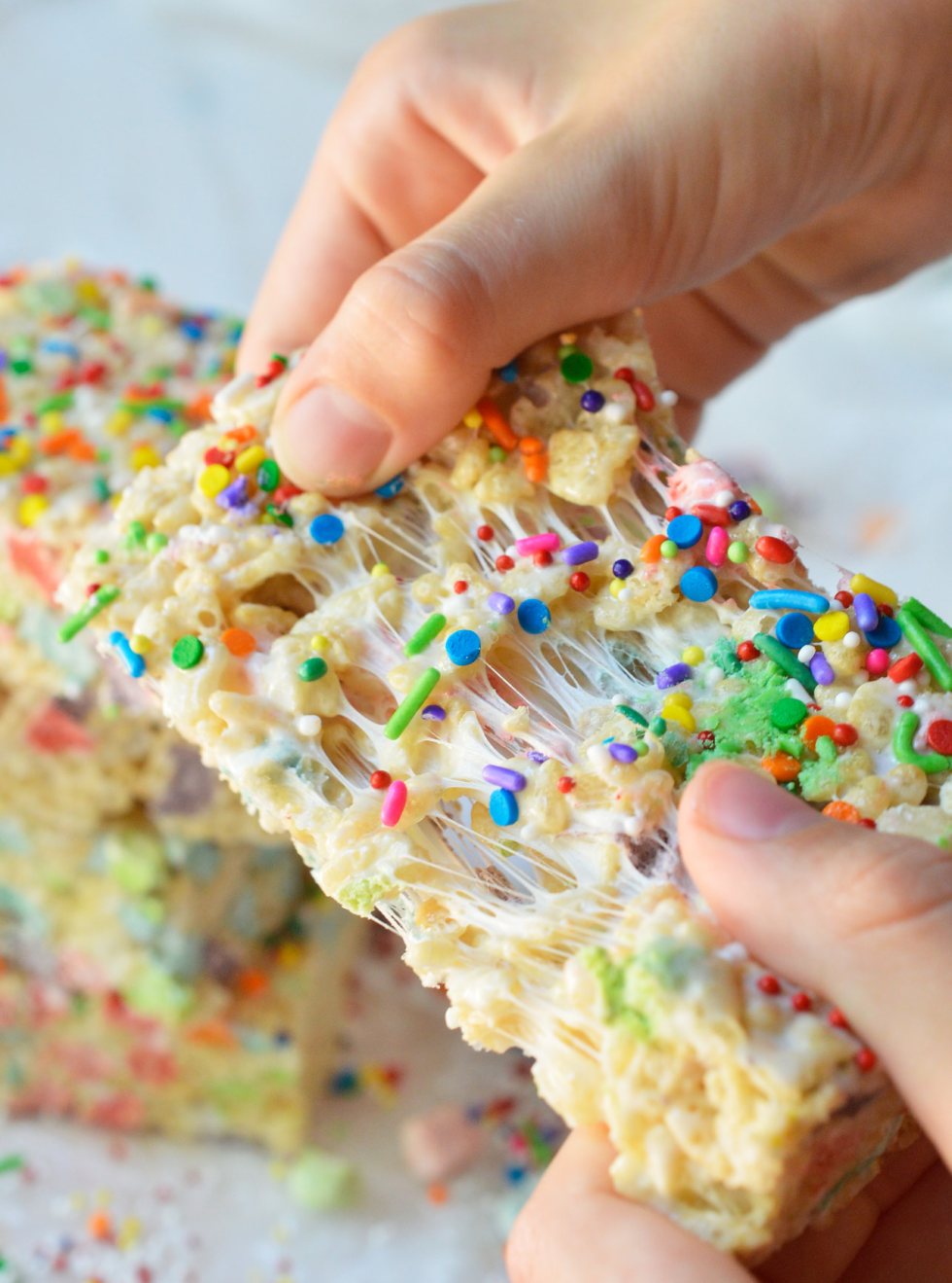 These Magical Rainbow Rice Crispy Treats are perfect for a surprise treat or a colorful unicorn party! This easy dessert recipe makes super chewy krispy treats full of magical charm marshmallows. Top them with rainbow sprinkles for the ultimate kid approved treat!