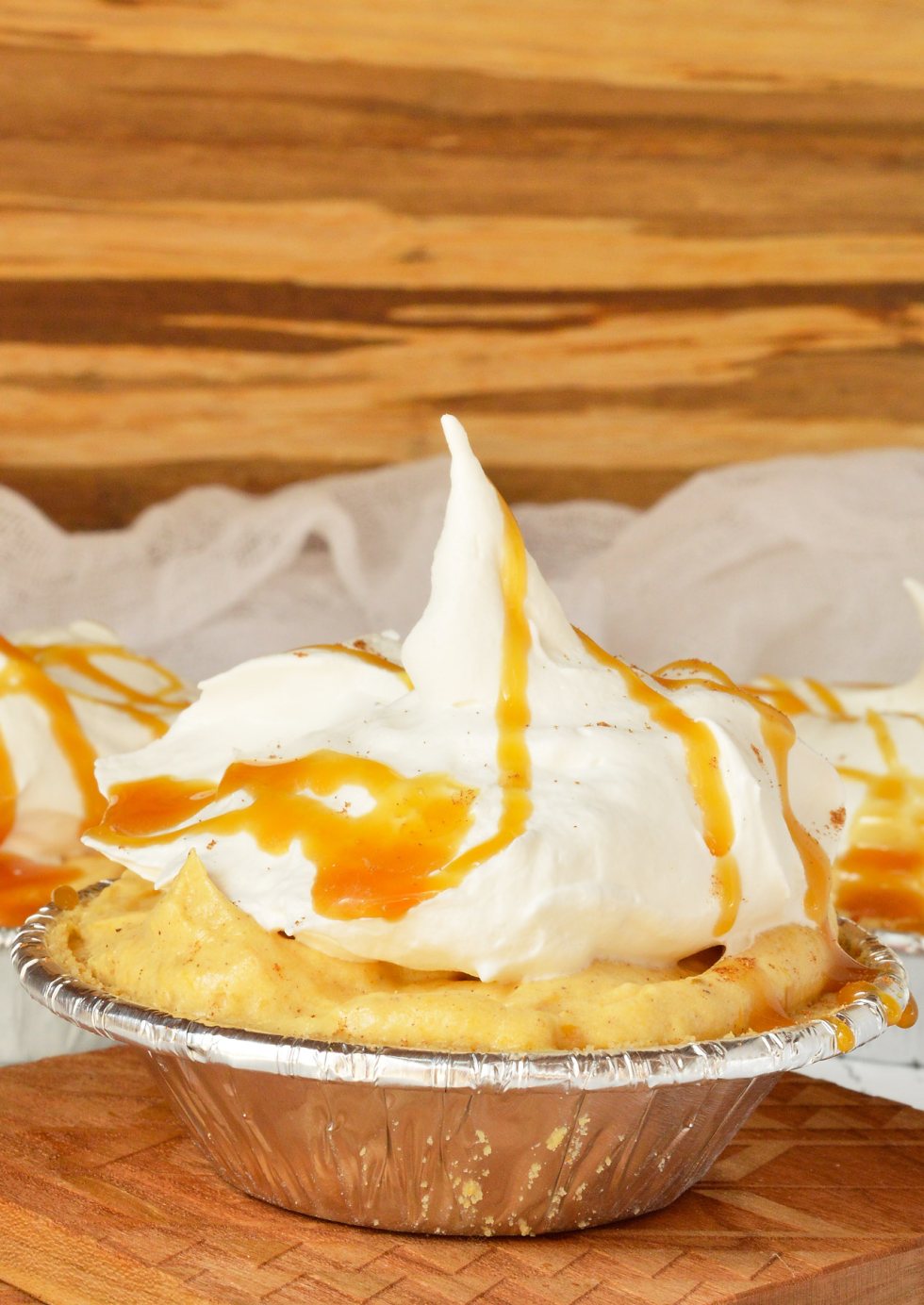 Don't slave away in the kitchen making holiday desserts! These No Bake Mini Pumpkin Cream Pies drizzled with caramel are quick, easy and sure to be a hit! This pudding pie recipe is also great for portion control thanks to the individual servings. #pie #dessert #thanksgiving