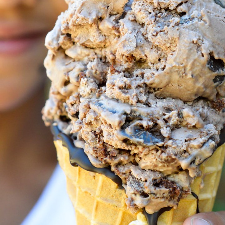 kid holding cone filled with chocolate ice cream