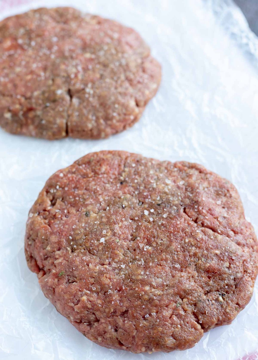 raw burger patties on wax paper