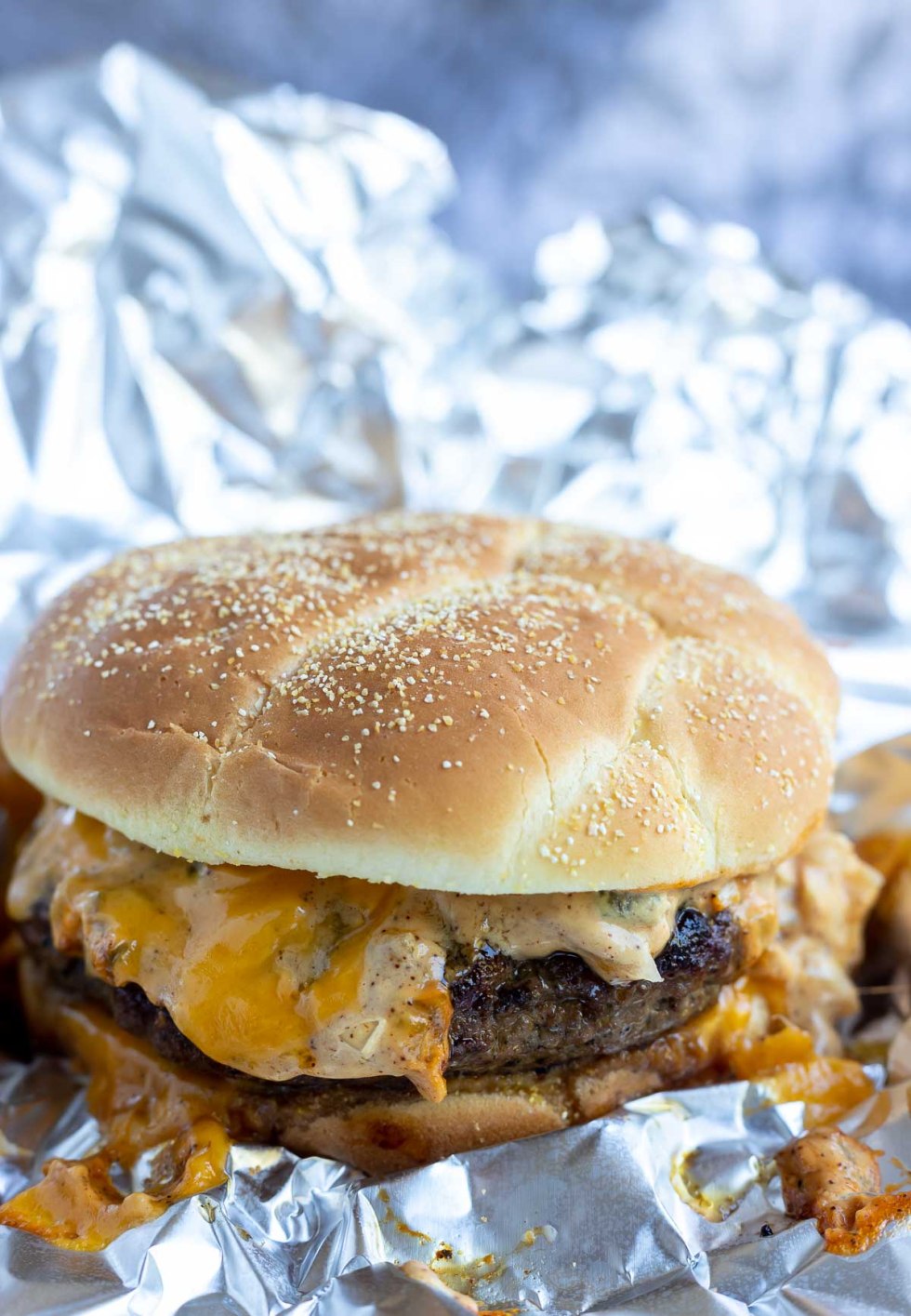 burger after being baked with cheese and sauce dripping down 