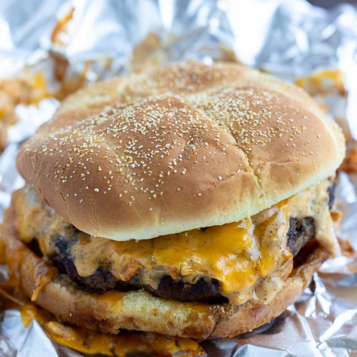 cooked prepared cheeseburger on tin foil