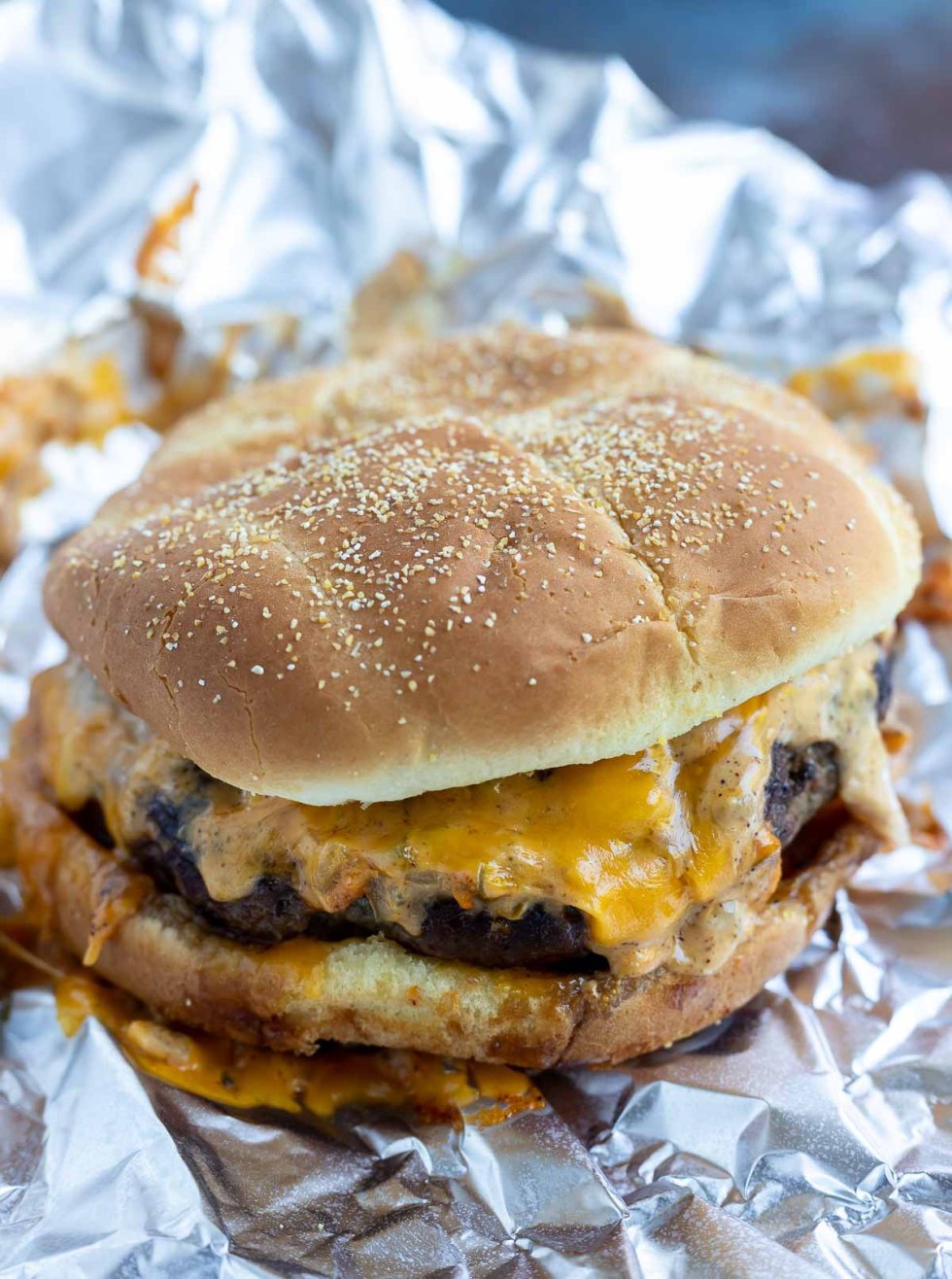 cooked prepared cheeseburger on tin foil