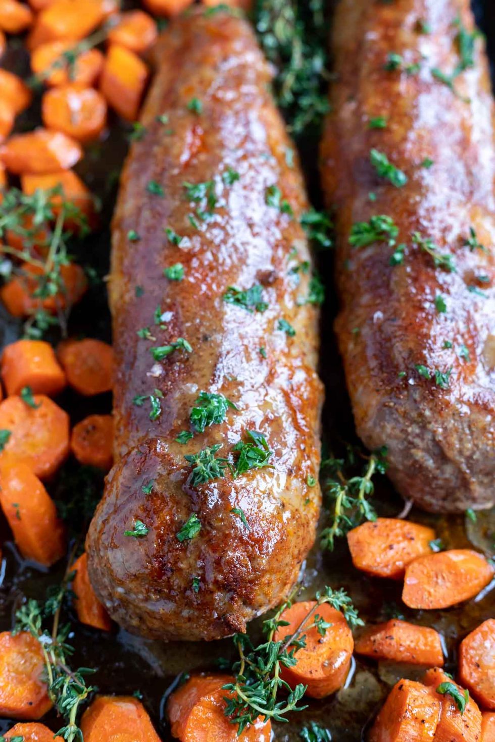 cooked pork tenderloin and carrots on pan