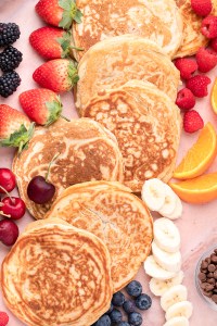 pancakes in a line next to fruit