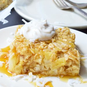 If you want a sweet and satisfying breakfast, this Pineapple Coconut Dairy Free Baked Oatmeal Recipe is perfect! This super simple recipe is a great way to liven up your morning oatmeal. Oatmeal, pineapple and coconut are baked and served like cake with a dollop of vanilla yogurt and a generous drizzle of maple syrup. This gluten free, vegetarian, dairy free breakfast will be a hit!