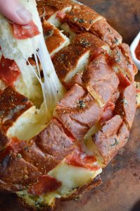 Perfect for any game day party, this Pull Apart Pizza Bread Recipe is super easy! Soft Hawaiian bread stuffed with pepperoni and cheese makes a fantastic appetizer!